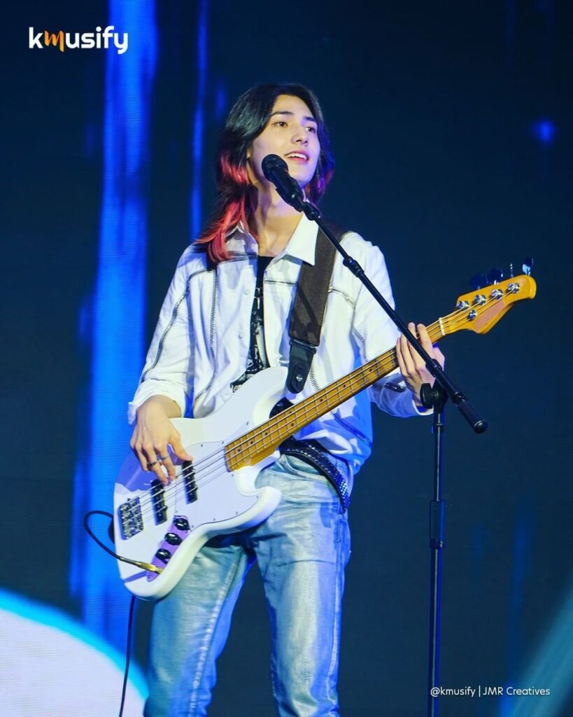 Xdinary Heroes Jooyeon playing a bass guitar.